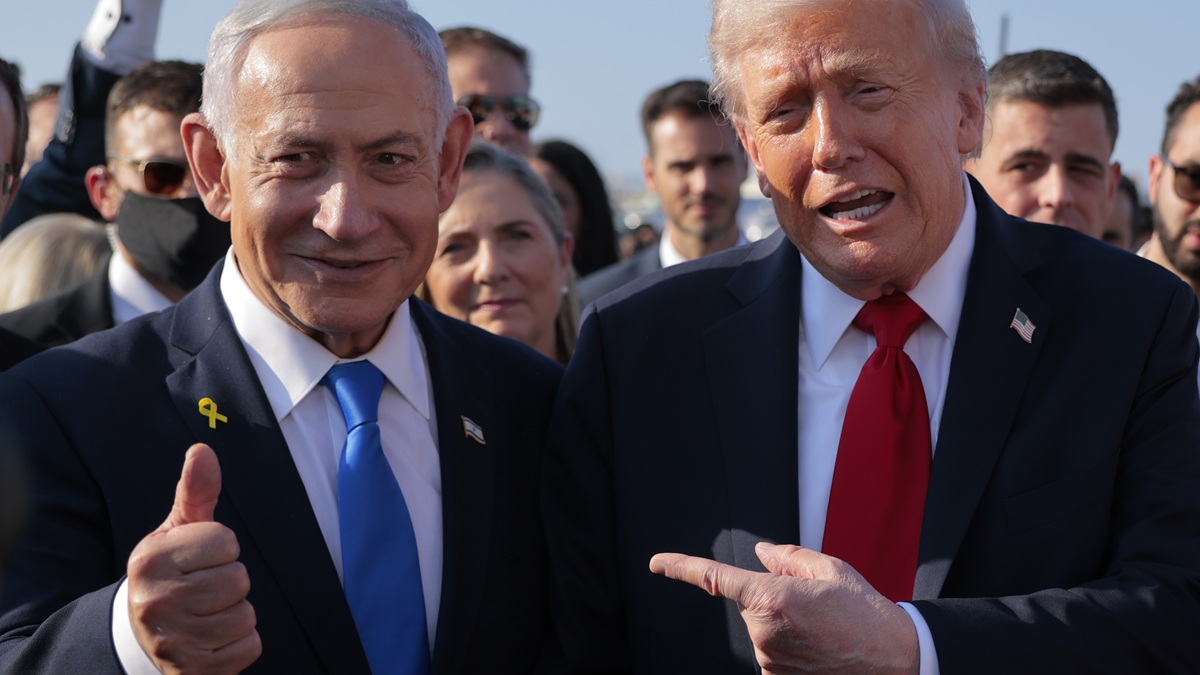 TEL AVIV, ISRAEL - OCTOBER 13: U.S. President Donald Trump speaks to Israeli Prime Minister Benjamin Netanyahu at Ben Gurion International Airport before boarding his plane to Sharm El-Sheikh, on October 13, 2025 in Tel Aviv, Israel. President Trump is visiting the country hours after Hamas released the remaining Israeli hostages captured on Oct. 7, 2023, part of a US-brokered ceasefire deal to end the war in Gaza.