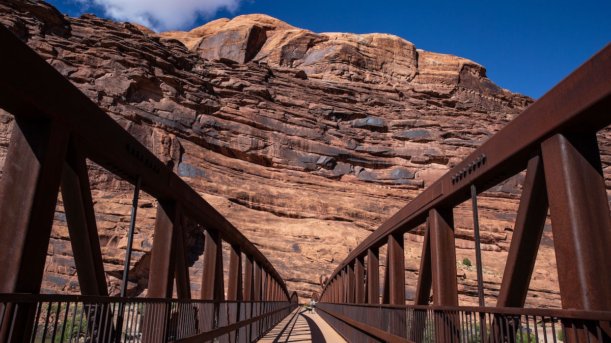 MOAB, UT - OCTOBER 3: A pedestrian and bicycle bridge over the Colorado River, located two miles from the entrance of Arches National Park, is viewed on October 3, 2023 near Moab, Utah. Arches National Park, one of the Fabulous Five Utah Parks, is located in southeastern Utah near the town of Moab. The park preserves a colorful eroded landscape of numerous canyons, mesas, balancing rocks, and buttes, along with nearly 2,000 natural sandstone arches.