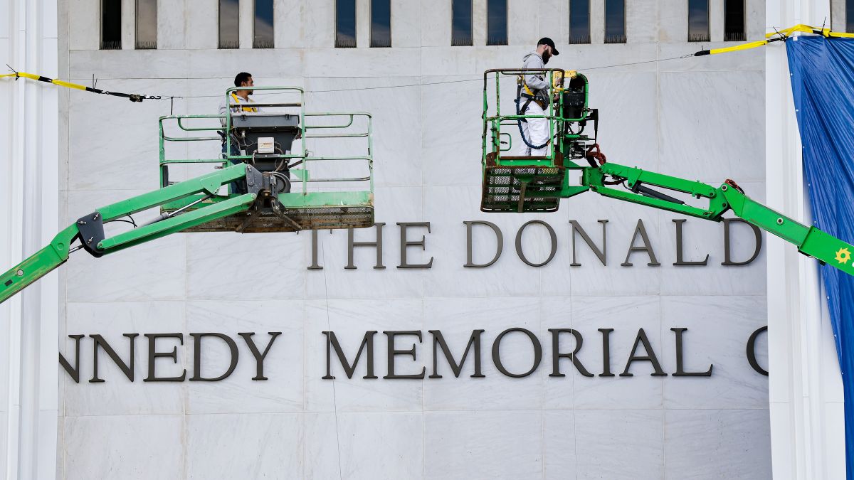 Workers adjust the name of the “John F. Kennedy Memorial Center for the Performing Arts" on December 19, 2025 in Washington, DC. The Kennedy Center Board of Trustees voted in what they say was a unanimous decision to rename the facility “The Donald J. Trump and The John F. Kennedy Memorial Center for the Performing Arts”. (Photo by Heather Diehl/Getty Images)