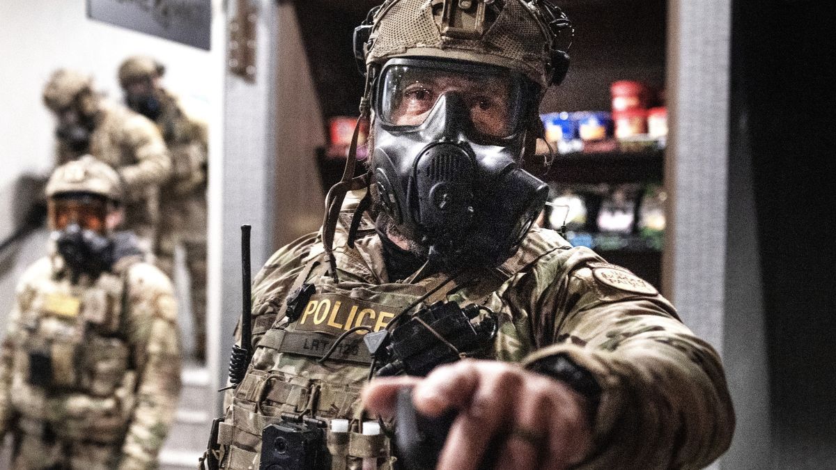 Federal agents enter the lobbly after breaking up a protest outside a hotel on January 25, 2026 in Minneapolis, Minnesota. The demonstrators, who broke windows and spray painted graffiti on the hotel, were protesting the business renting rooms to border patrol agents. Yesterday federal immigration agents shot and killed Alex Pretti, an ICU nurse at a VA medical center, during a brief altercation in the Eat Street district of Minneapolis. (Photo by Scott Olson/Getty Images)