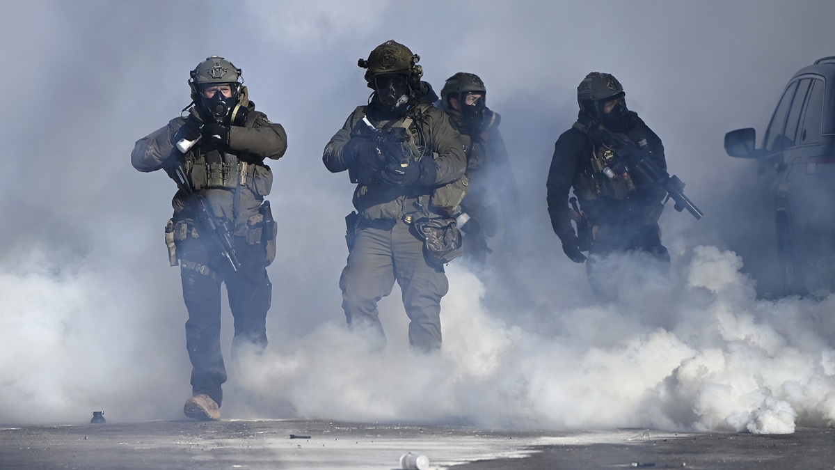 MINNEAPOLIS, MINNESOTA - JANUARY 24: Federal agents point weapons amid tear gas fired at protestors on January 24, 2026 in Minneapolis, Minnesota. Earlier agents allegedly shot and killed a protestor amid a scuffle to arrest him. The Trump administration has sent a reported 3,000 federal agents into the area, with more on the way, as they make a push to arrest undocumented immigrants in the region. (Photo by Stephen Maturen/Getty Images)