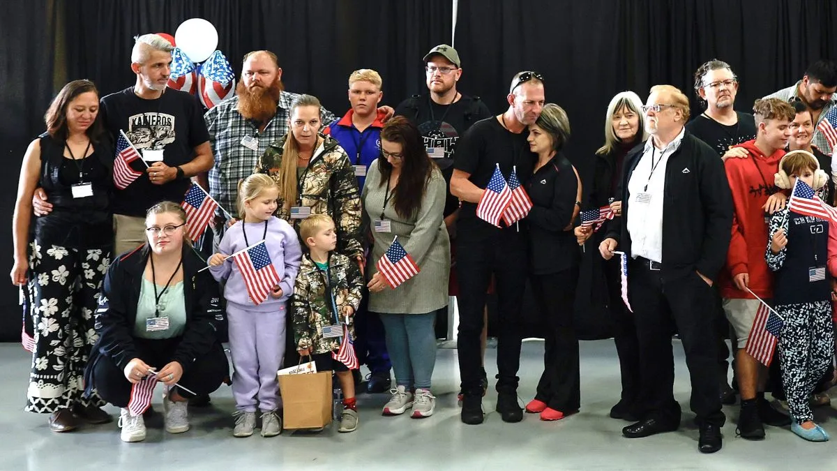 Newly arrived South Africans wait to hear welcome statements from U.S. government officials in a hangar at Atlantic Aviation Dulles near Washington Dulles International Airport on May 12, 2025 in Dulles, Virginia. Dozens of white South Africans, also called Afrikaners, accepted an invitation from the Trump Administration to come to the United States as refugees. They say they are fleeing job discrimination and racial violence in their home country. Trump has halted virtually all refugee admissions for people fleeing famine and war but has created an expedited path into the U.S. for Afrikaners, descendants of white Europeans who created and led the brutal apartheid regime in South Africa from 1948 to 1994. (Photo by Chip Somodevilla/Getty Images)