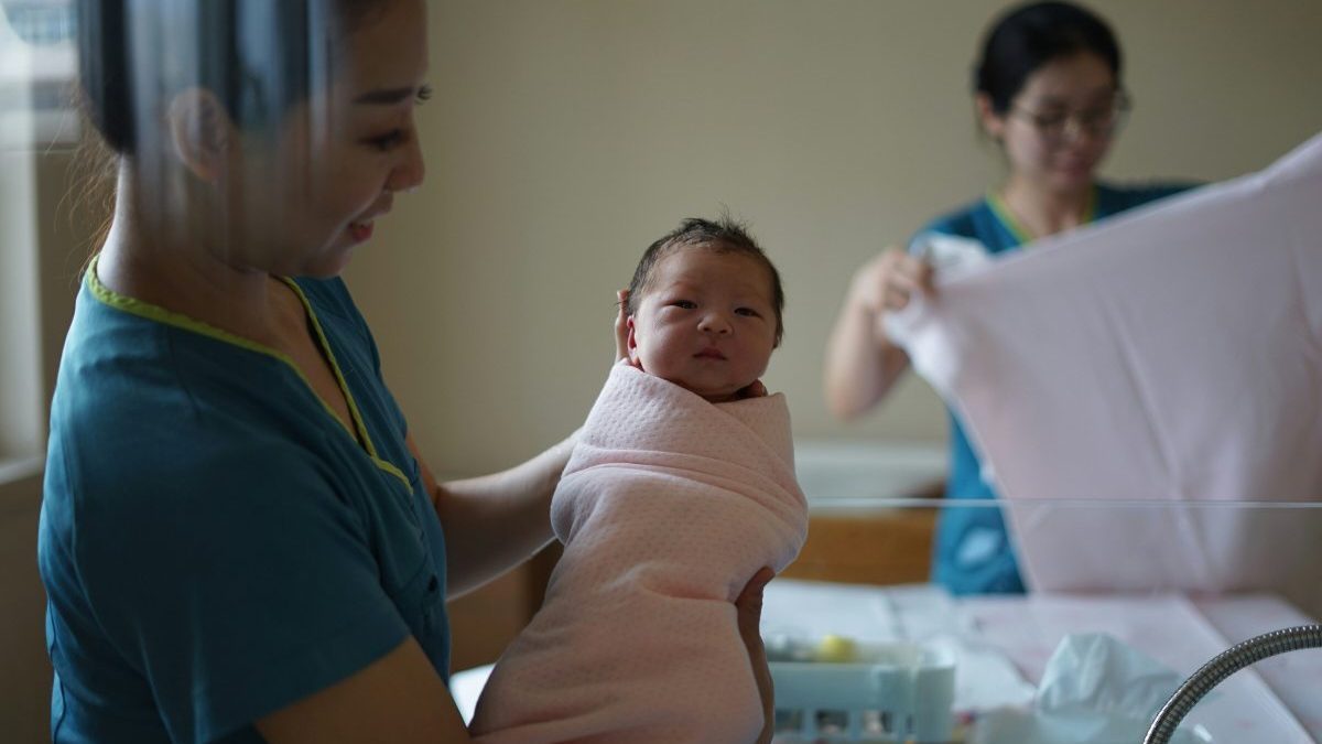 woman carrying newborn baby
