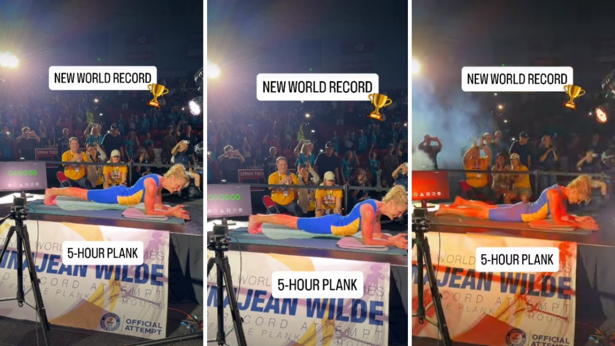 A woman is planking in front of the crowd.